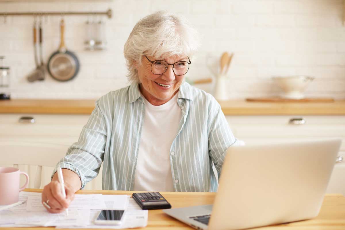 Une femme senior calcule ses aides OSCAR retraite