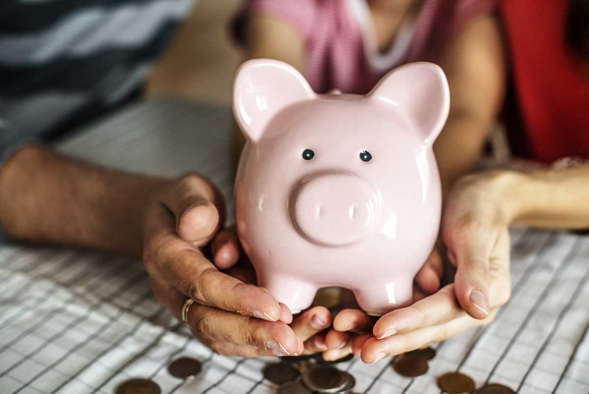 Une femme senior tient une tirelire dans ses mains pour calculer le montant du cumul de l'ASPA et de sa retraite complémentaire