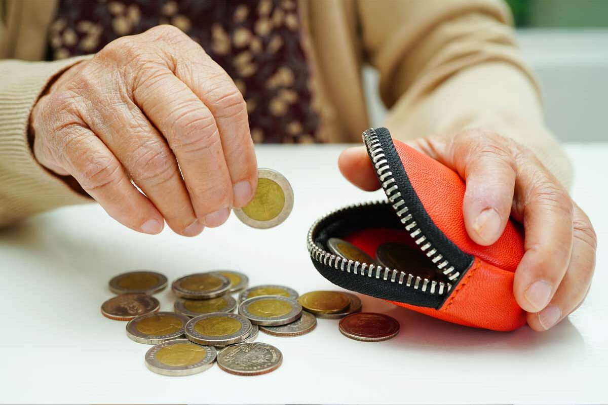 Une dame senior comptant son argent et qui a besoin de l'aide ASPA