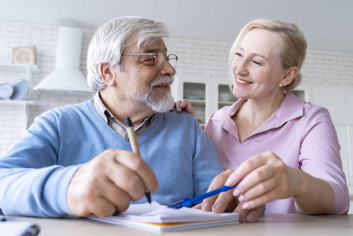 Un homme handicapé et une femme étudient un dossier d'allocation AAH