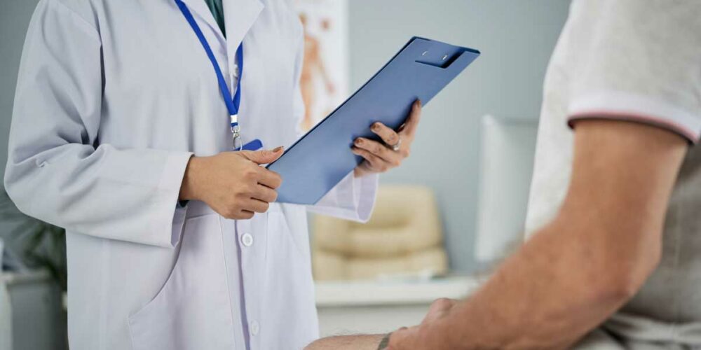 Une femme médecin examine en patient en affection longue durée - ALD