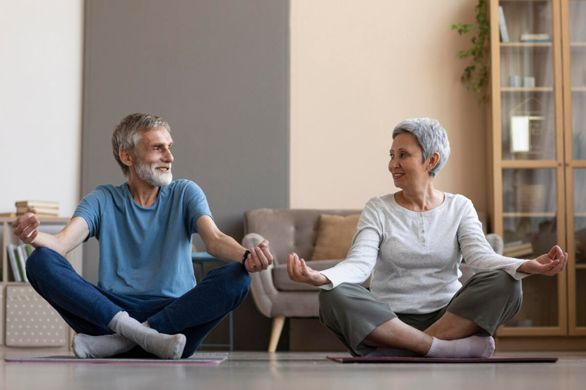 Un couple de seniors qui font du yoga ensemble