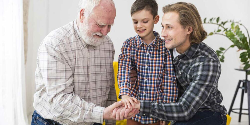 Un accueillant familial, son fils et le senior accueilli se serrent la main