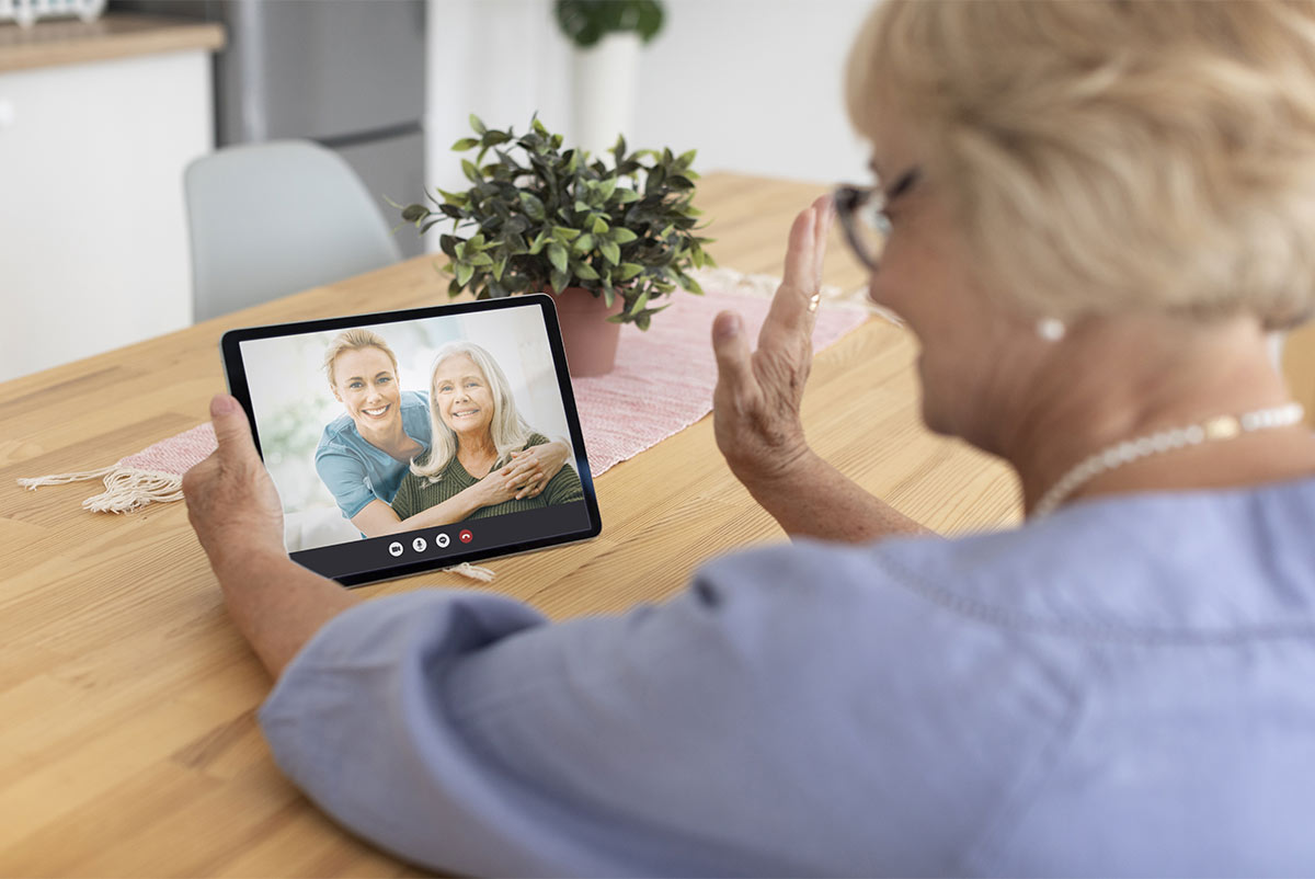 Femme qui se sert de sa tablette pour rester connectée à sa famille